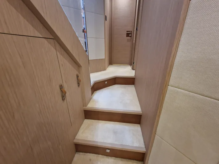 Sandrali Yacht Photos Pics Staircase inside 2016 Beneteau Monte Carlo 6 yacht, featuring elegant wood finish.
