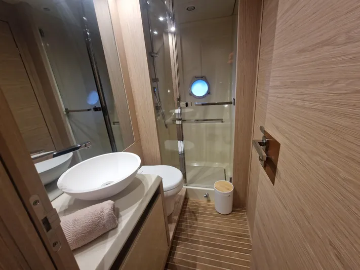 Sandrali Yacht Photos Pics Luxurious bathroom in 2016 Beneteau Monte Carlo 6 yacht with modern fixtures and porthole window.