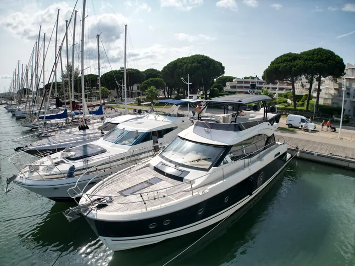 Sandrali Yacht Photos Pics 2016 Beneteau Monte Carlo 6 yacht docked in a marina, surrounded by sailboats.