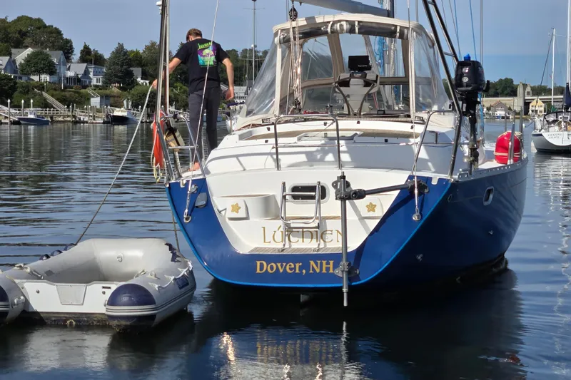 Luthien Yacht Photos Pics Jeanneau Sun Odyssey 42 Center Cockpit sailboat docked, 1998 model, in a scenic harbor.