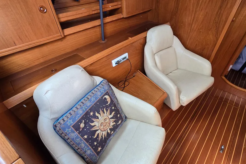 Luthien Yacht Photos Pics Cozy interior of 1998 Jeanneau Sun Odyssey 42 with plush seating and celestial-themed pillow.