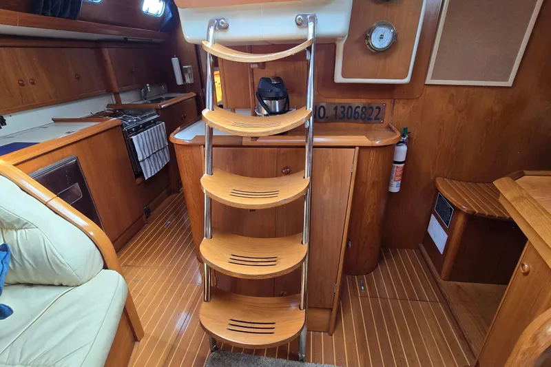 Luthien Yacht Photos Pics Interior of 1998 Jeanneau Sun Odyssey 42 Center Cockpit with wooden finish and compact kitchen.