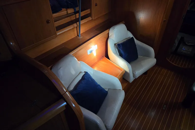 Luthien Yacht Photos Pics Interior of 1998 Jeanneau Sun Odyssey 42 with two chairs and wooden flooring.