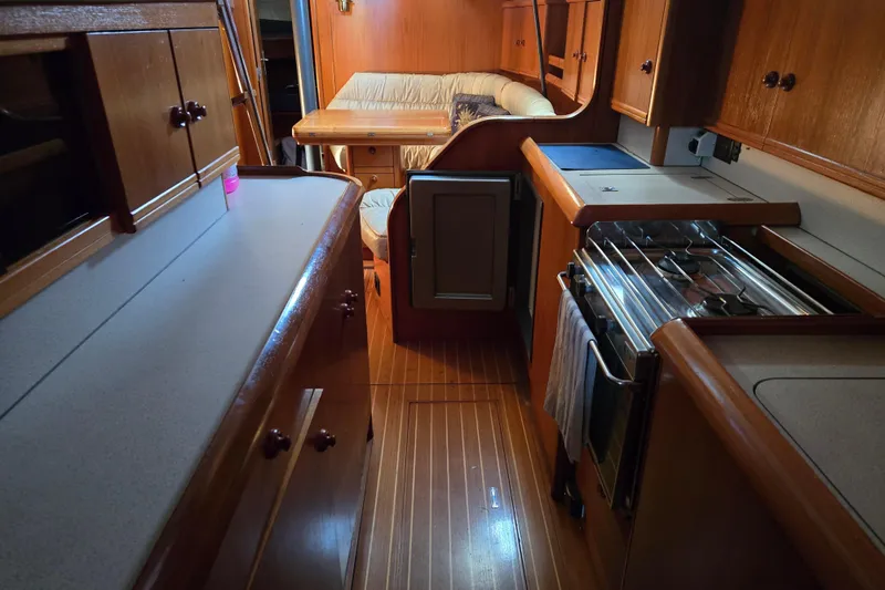 Luthien Yacht Photos Pics Interior of 1998 Jeanneau Sun Odyssey 42 with kitchen and seating area.