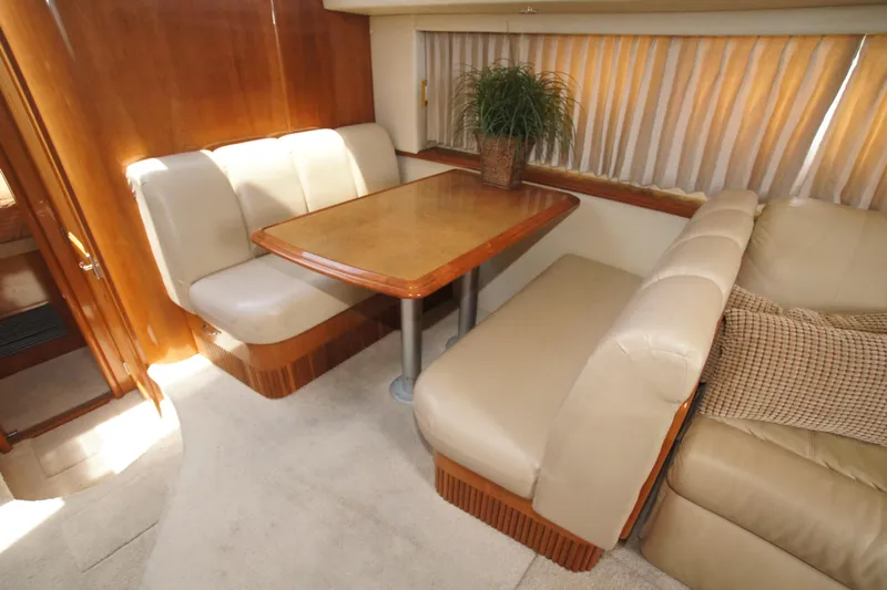 Debra Lynn Yacht Photos Pics Luxurious interior of 2005 Carver 44 Cockpit Motor Yacht with plush seating and wooden table.