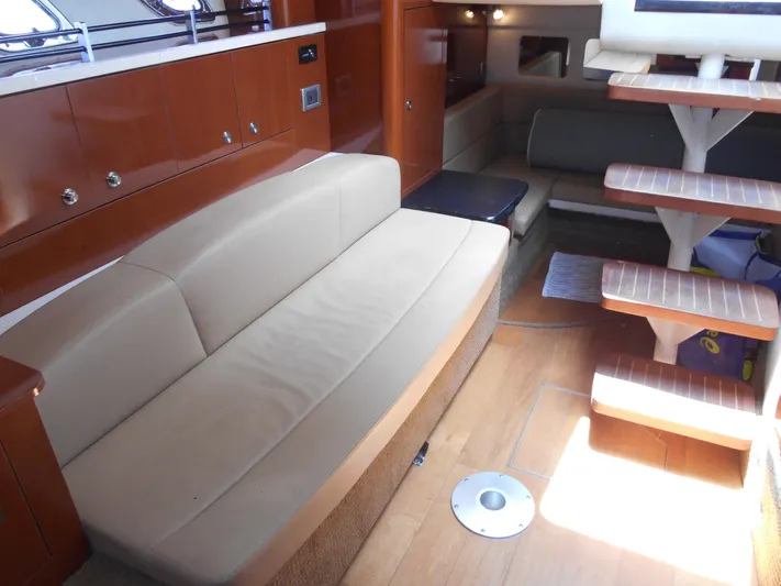 Legasea Yacht Photos Pics Interior of 2013 Sea Ray 330 Sundancer with beige seating and wooden accents.