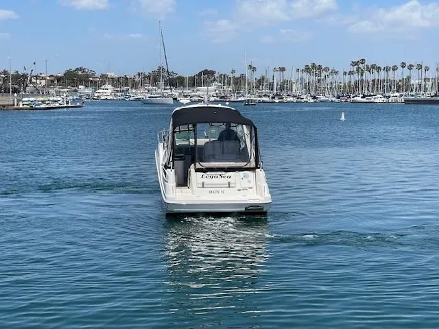 Legasea Yacht Photos Pics 2013 Sea Ray 330 Sundancer cruising in a marina with palm trees and boats.