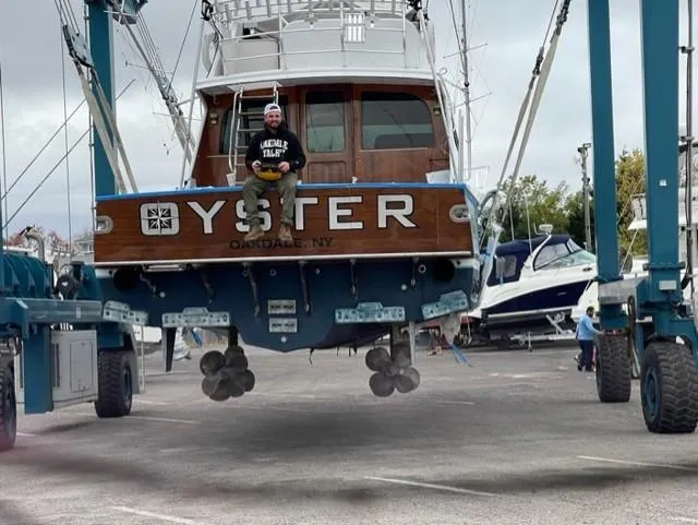 Oyster Yacht Photos Pics Custom Carolina Ritchie Howell 60 Sportfish 2012 boat in dry dock with person sitting on stern.