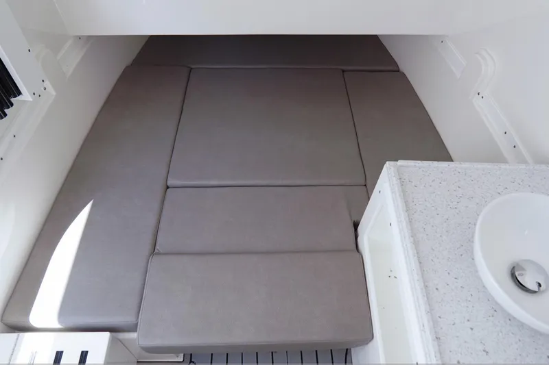  Yacht Photos Pics 2023 Tidewater 380 CC Adventure cabin interior with cushioned seating and sink.