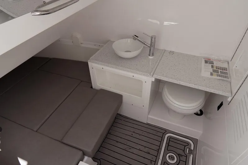  Yacht Photos Pics 2023 Tidewater 380 CC Adventure cabin with modern sink, toilet, and cushioned seating.