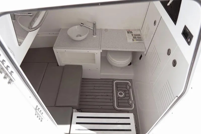  Yacht Photos Pics Interior of 2023 Tidewater 380 CC Adventure boat, featuring a compact bathroom with sink and toilet.