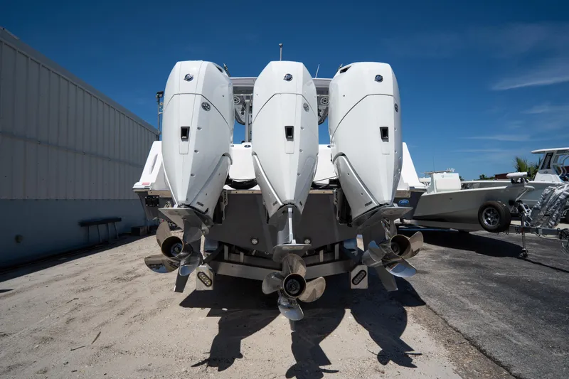  Yacht Photos Pics 2023 Tidewater 380 CC Adventure boat with triple outboard engines, parked outdoors.