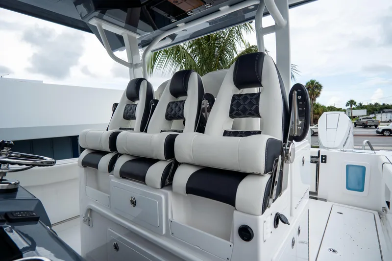  Yacht Photos Pics 2023 Tidewater 380 CC Adventure boat seats, luxurious design, white and black upholstery.