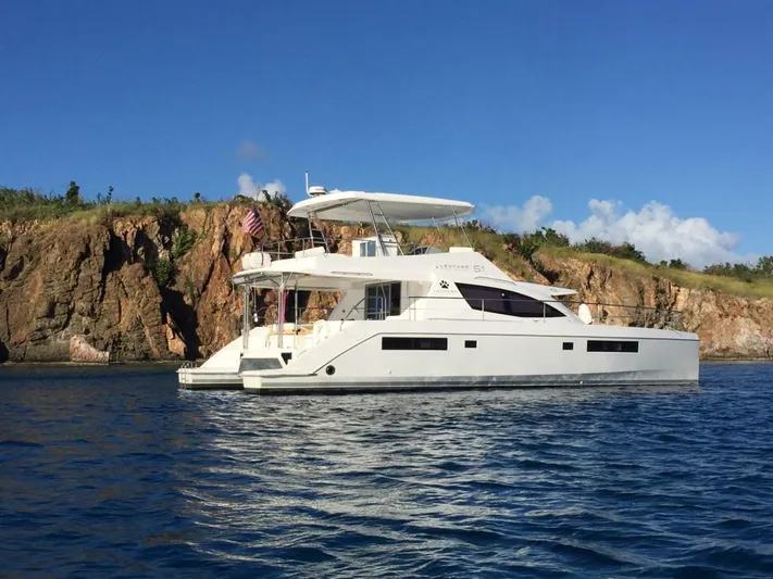 Ida Cat Yacht Photos Pics 2017 Leopard 51 Powercat yacht cruising near rocky coastline under clear blue sky.