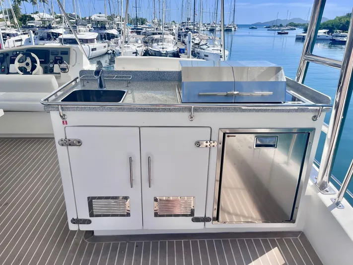 Ida Cat Yacht Photos Pics Outdoor kitchen on 2017 Leopard 51 Powercat yacht with sink and grill, docked at marina.