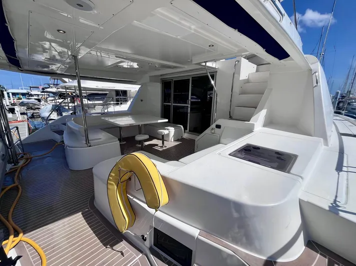 Ida Cat Yacht Photos Pics 2017 Leopard 51 Powercat yacht deck with seating, table, and stairs in marina setting.