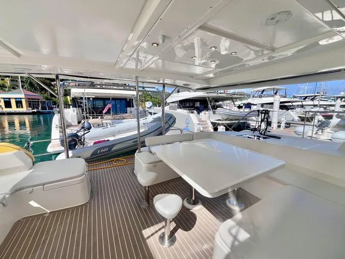 Ida Cat Yacht Photos Pics Spacious deck of 2017 Leopard 51 Powercat with seating and table, docked at marina.