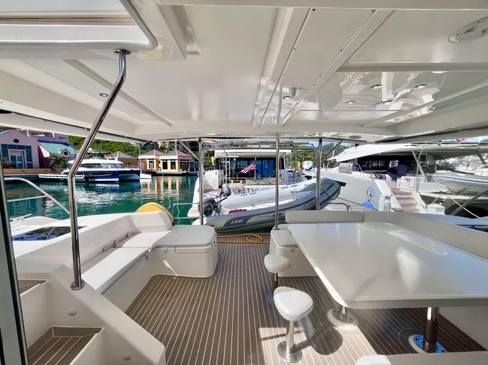 Ida Cat Yacht Photos Pics 2017 Leopard 51 Powercat yacht interior with seating and table, docked at marina.