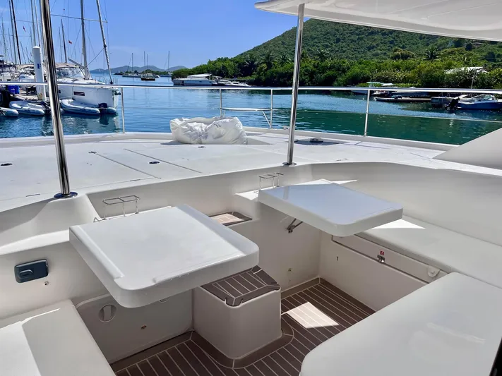 Ida Cat Yacht Photos Pics 2017 Leopard 51 Powercat yacht deck with seating and tables, docked in a scenic marina.