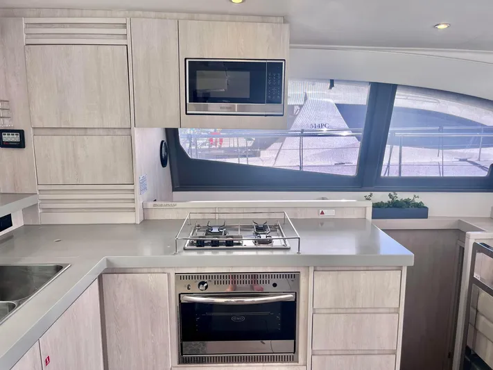 Ida Cat Yacht Photos Pics Modern kitchen interior of 2017 Leopard 51 Powercat yacht with stove, oven, and microwave.