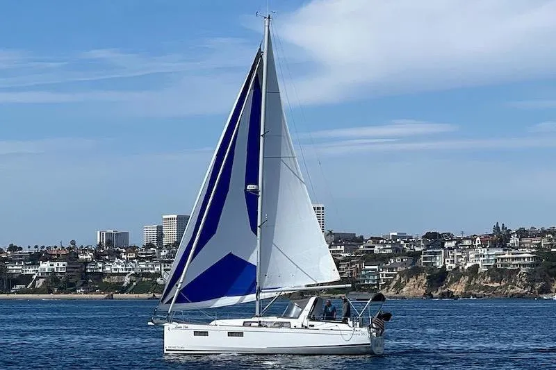 Dulce Vida Yacht Photos Pics 2022 Beneteau Oceanis 35.1 sailboat on water with coastal cityscape background.