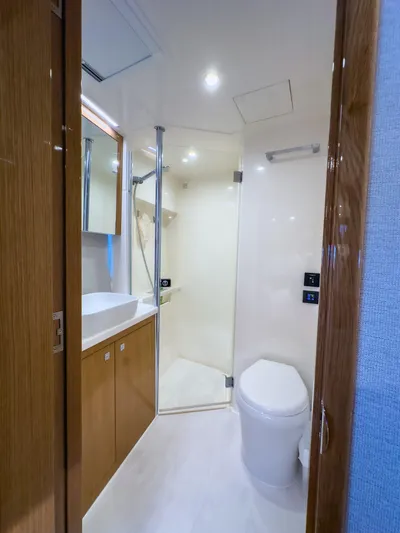  Yacht Photos Pics 2024 Riviera SMY 46 yacht bathroom with modern fixtures and wooden cabinetry.