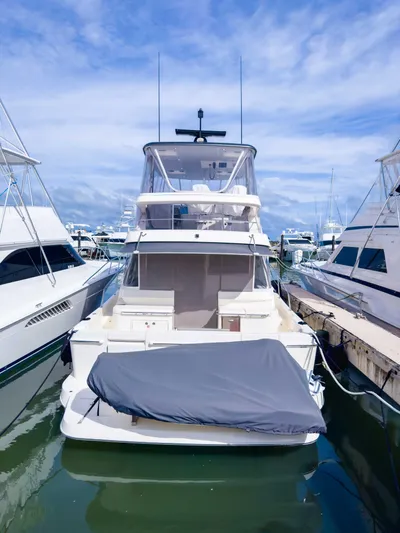  Yacht Photos Pics 2024 Riviera SMY 46 yacht docked at marina under clear blue sky.