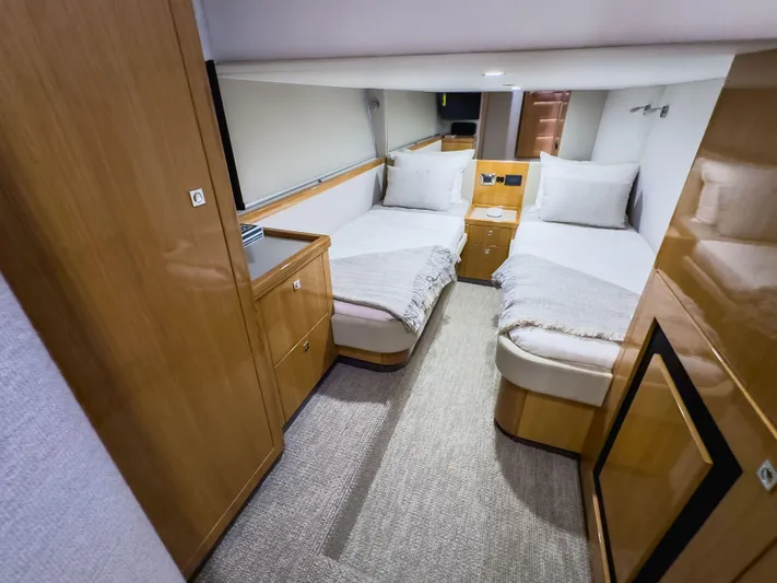  Yacht Photos Pics 2024 Riviera SMY 46 yacht cabin with twin beds, wooden cabinetry, and modern decor.