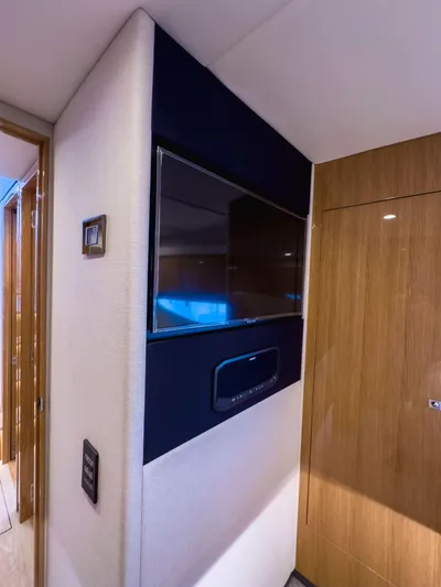  Yacht Photos Pics 2024 Riviera SMY 46 yacht interior with mounted TV and wooden paneling.