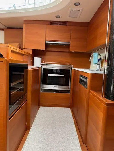  Yacht Photos Pics Interior of 2019 Solaris 64RS yacht kitchen with wooden cabinetry and modern appliances.