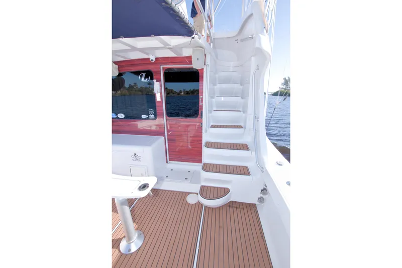 Fish Daddy Yacht Photos Pics 1998 Luhrs 36 Convertible boat with wooden deck and white staircase, docked by the water.