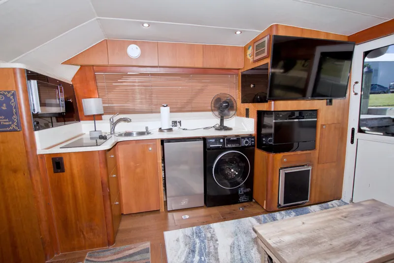 Fish Daddy Yacht Photos Pics 1998 Luhrs 36 Convertible yacht interior with kitchen, appliances, and wooden cabinetry.