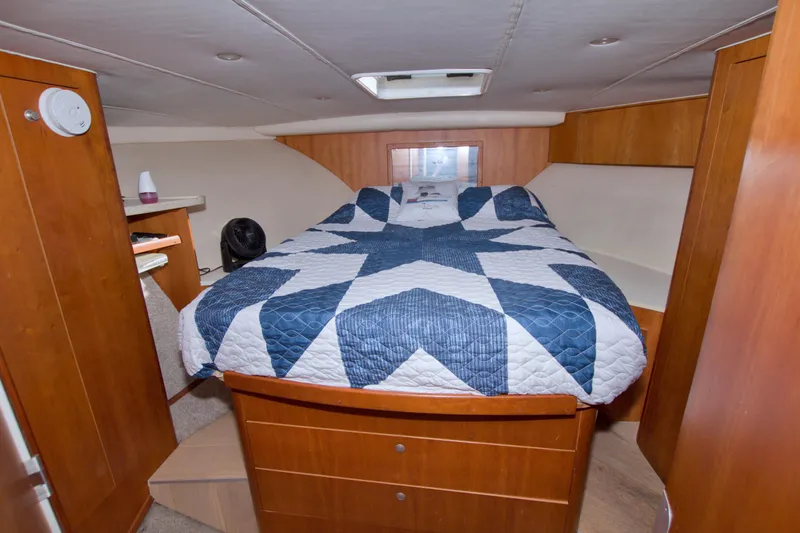 Fish Daddy Yacht Photos Pics 1998 Luhrs 36 Convertible cabin with quilted bedspread and wooden cabinetry.