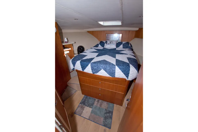Fish Daddy Yacht Photos Pics 1998 Luhrs 36 Convertible cabin with a cozy bed and wooden cabinetry.