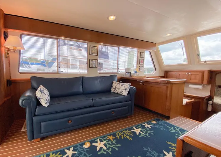 Sandpiper Yacht Photos Pics Interior of 2004 Mainship 340 yacht with blue sofa, wooden cabinetry, and nautical-themed decor.