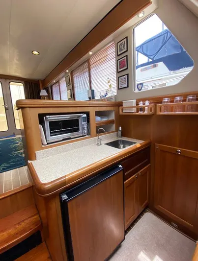 Sandpiper Yacht Photos Pics 2004 Mainship 340 interior kitchen with sink, mini-fridge, and microwave.