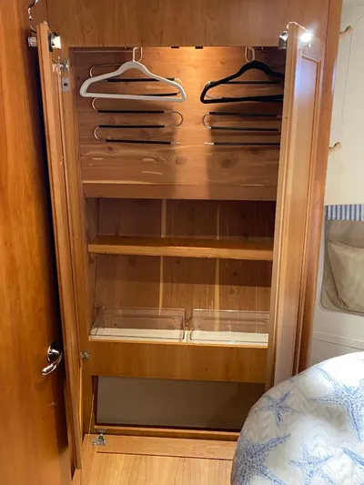 Sandpiper Yacht Photos Pics Wooden closet interior with hangers and shelves on a 2004 Mainship 340 boat.