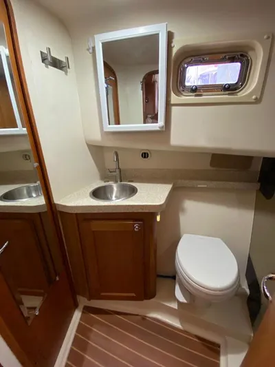 Sandpiper Yacht Photos Pics 2004 Mainship 340 yacht bathroom with sink, mirror, and toilet.