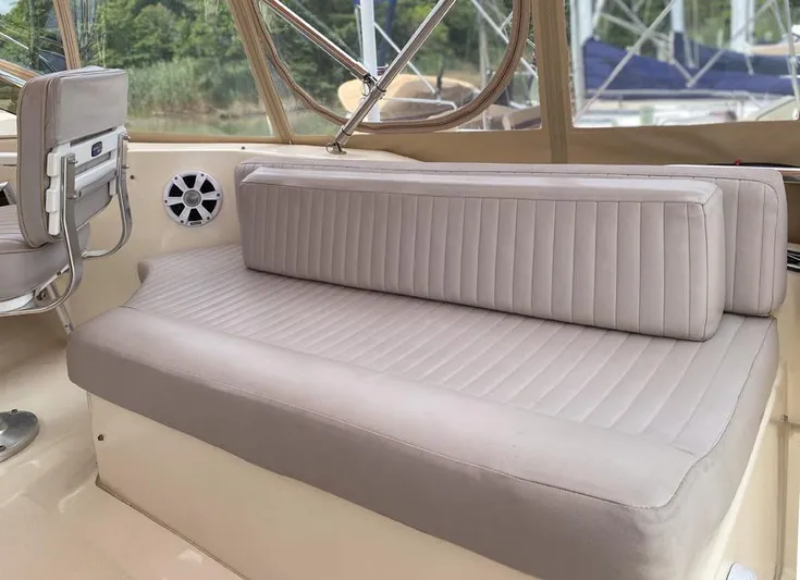 Sandpiper Yacht Photos Pics 2004 Mainship 340 boat interior with beige seating and speaker, showcasing comfort and style.