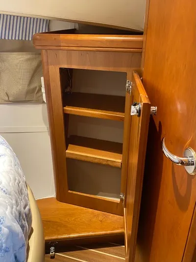 Sandpiper Yacht Photos Pics Wooden cabinet with open door inside a 2004 Mainship 340 boat interior.
