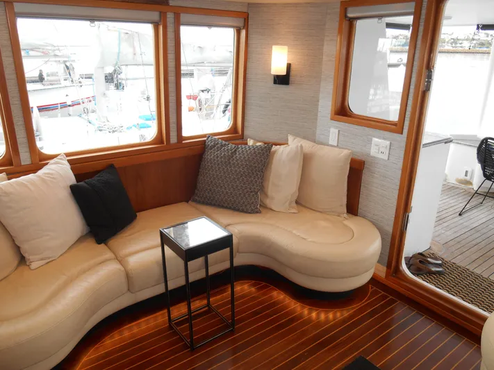 Suspense Yacht Photos Pics Luxurious 2005 Inace Trawler interior with curved seating, cushions, and wooden flooring.