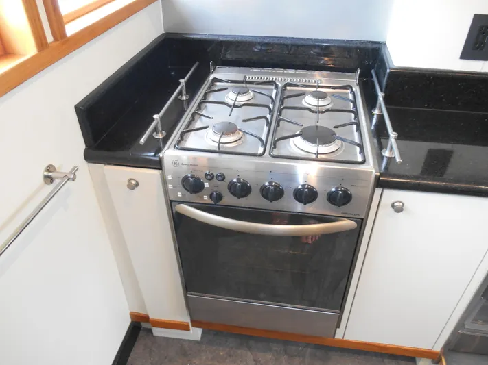 Suspense Yacht Photos Pics Stainless steel stove in 2005 Inace Trawler kitchen with black countertops.