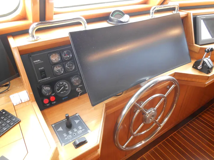 Suspense Yacht Photos Pics Control panel of a 2005 Inace Trawler with steering wheel and navigation instruments.