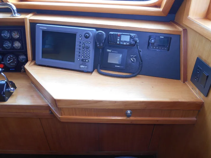 Suspense Yacht Photos Pics 2005 Inace Trawler navigation equipment with GPS and communication devices on wooden console.