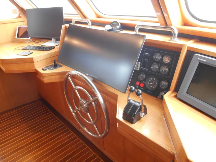 Suspense Yacht Photos Pics Pilothouse of 2005 Inace Trawler with steering wheel, monitors, and control panel.