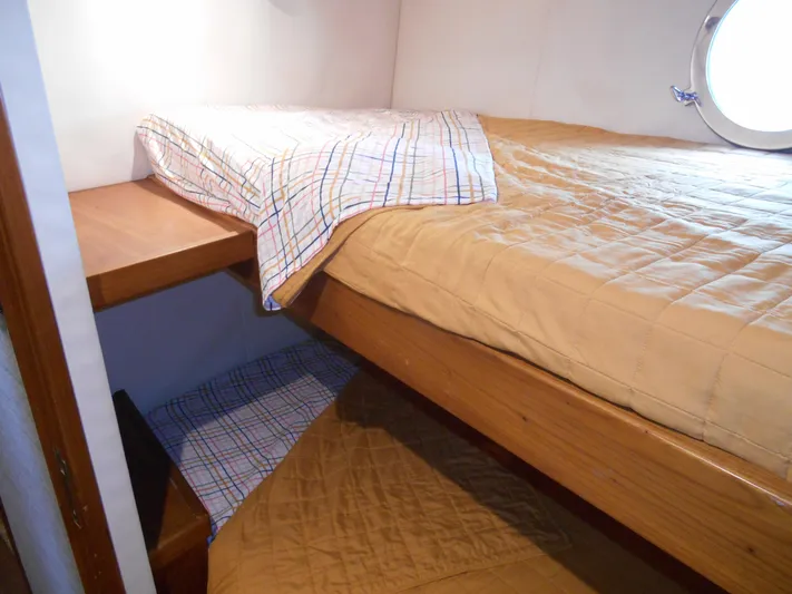 Suspense Yacht Photos Pics Cozy cabin interior of 2005 Inace Trawler with wooden bunk beds and porthole.