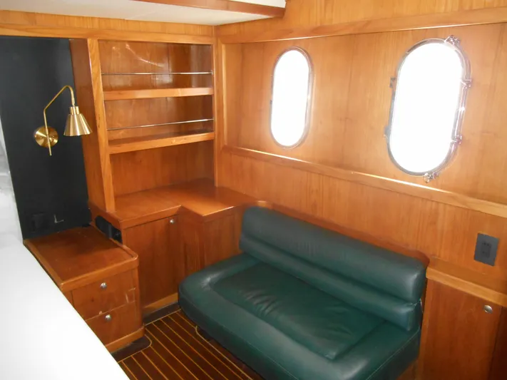 Suspense Yacht Photos Pics 2005 Inace Trawler interior with wooden cabinetry, green sofa, and porthole windows.