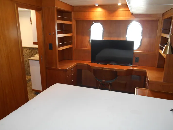 Suspense Yacht Photos Pics 2005 Inace Trawler interior with wooden desk, TV, and porthole windows.