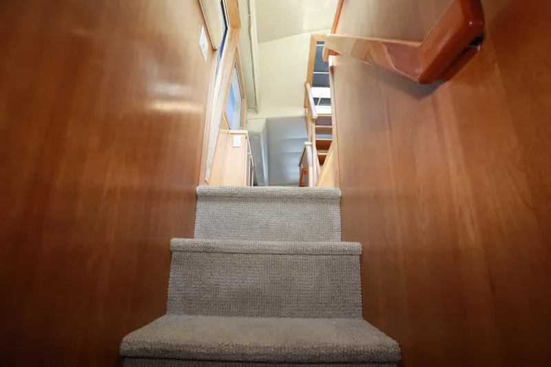 Ecto Boyz Yacht Photos Pics Staircase inside 2005 Navigator 53 Classic yacht with wooden walls and carpeted steps.