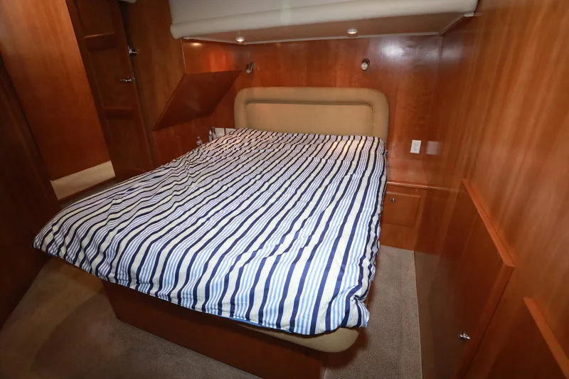 Ecto Boyz Yacht Photos Pics Cozy bedroom in 2005 Navigator 53 Classic yacht with striped bedding and wooden interior.